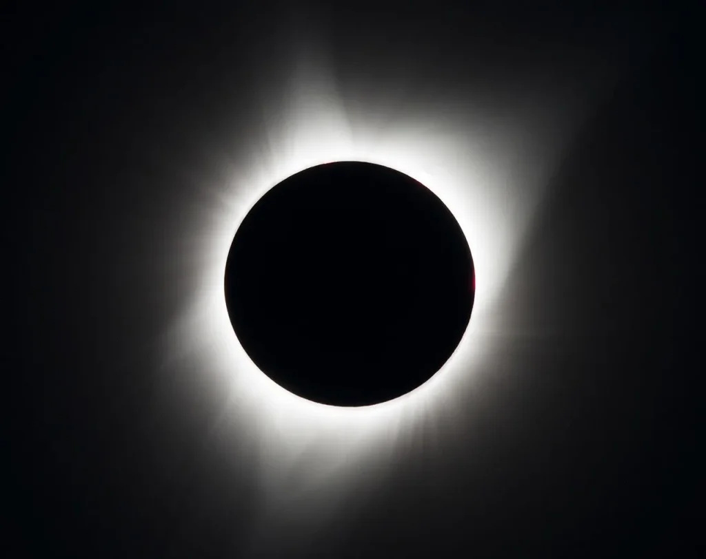 Sun blocked by Moon in total eclipse, with just the solar corona visible as a glow around the silhouetted Moon