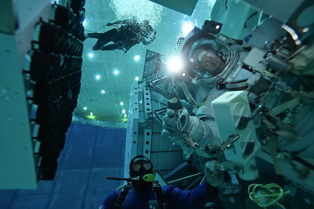 Photo of a man in a spacesuit in a pool.