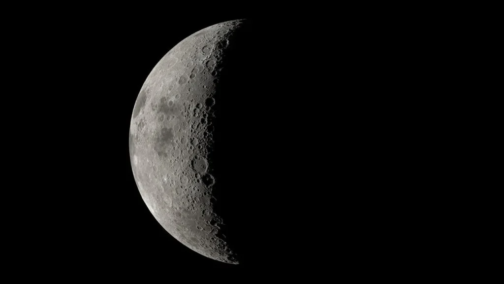 A large sphere is prominent in the center of the image. It is pockmarked with indentations and is generally grey, with patches of dark.