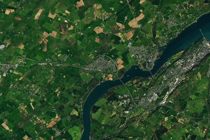 The long-named town in Wales appears as a gray patch amidst a bucolic image with green farmland bordering the Menai Strait. Two bridges mark an area known for treacherous whirlpools.
