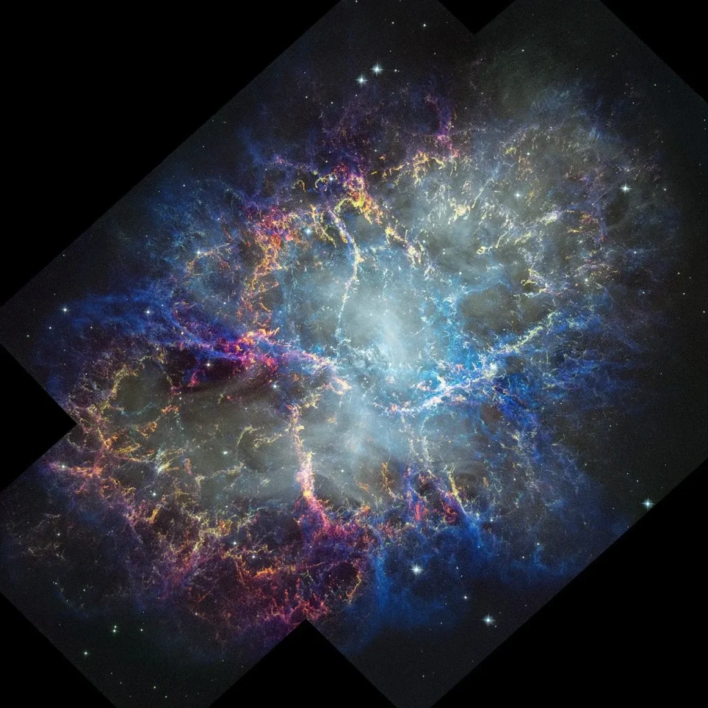 Colorful nebula in space with a white haze throughout that is more concentrated in the center with a rippling effect. Colorful gas filaments appear to splash outward from the nebula center, colored yellow, magenta, and blue. A faint black border with right angles at the corners of the images show where the telescope’s field of view stopsdotted line with right angles shows the borders of the telescope’s image. Small white stars dot the background.