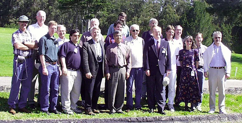 Members of the 1996-2001 Landsat Science Team standing outside against a background to trees.