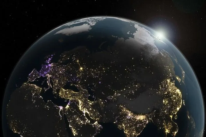 A data visualization shows changes in artificial light at night across the Eastern Hemisphere from 2014 to 2022, with increases shown in yellow and orange and decreases shown in purple.