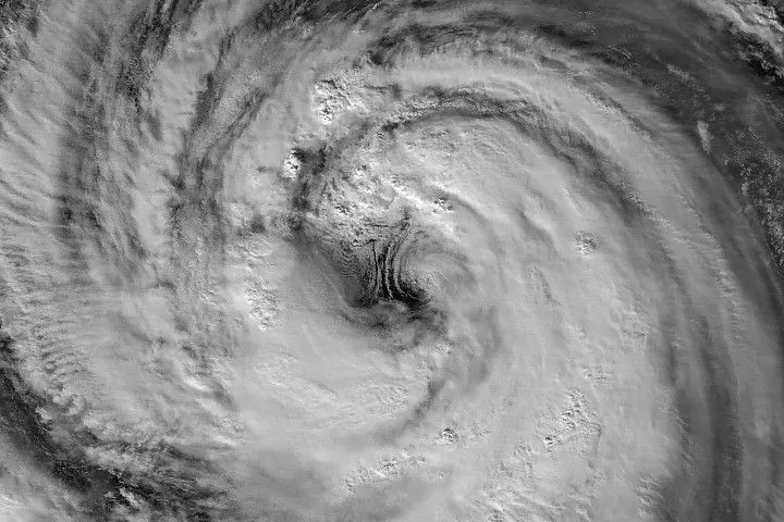 A nighttime satellite image highlights the structure of a typhoon’s large eye and surrounding eyewall.