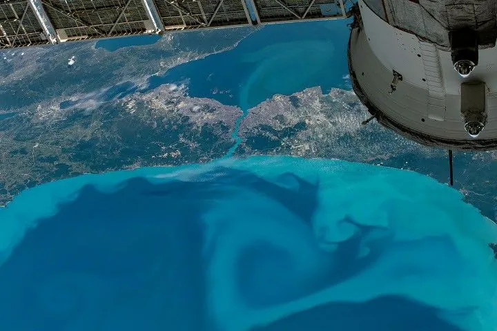 A downward looking photograph shows a detailed view of the southwestern side of the Black Sea, where turquoise swirls extend from the coast and across a narrow strait leading to the Sea of Marmara.