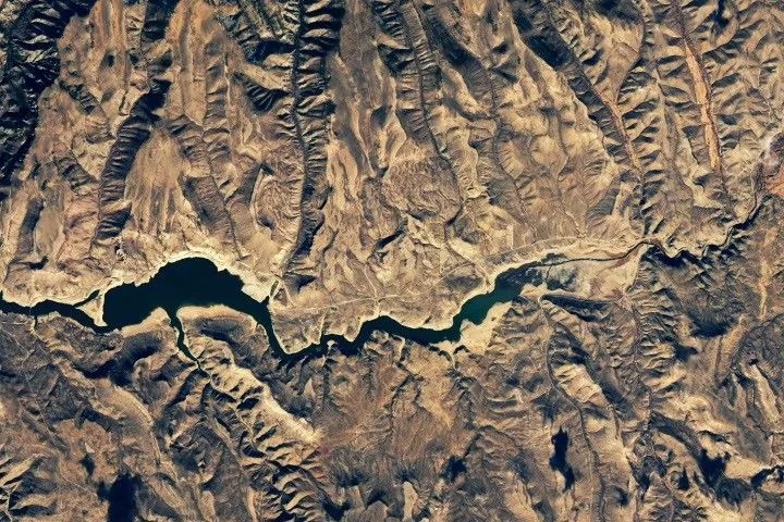 The second image in the pair shows the same part of the reservoir in November 2021, when water levels were much lower and its color was much greener.