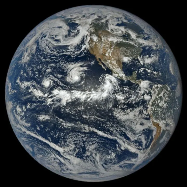 In a full-disk satellite view of Earth, three tropical cyclones—named Lowell, Karina, and Marie—swirl above the blue waters of the Pacific Ocean and to the west of Central America.