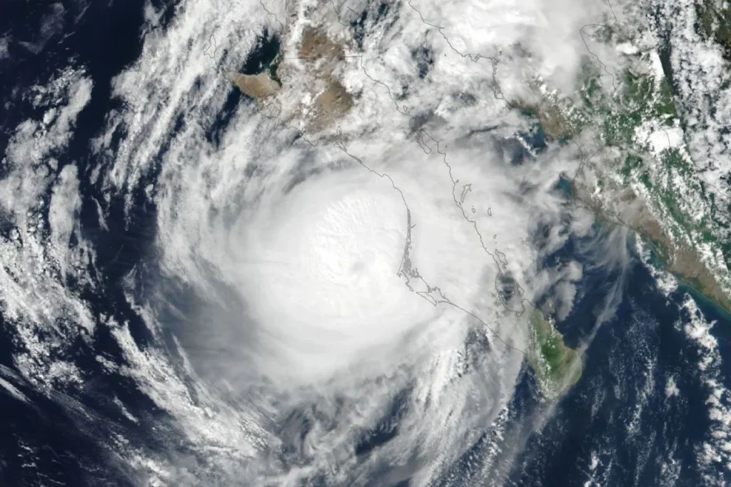 Hurricane Polo’s clouds spiral over the Pacific Ocean and the Baja California peninsula. The storm’s faint eye is just off the west coast of the peninsula.